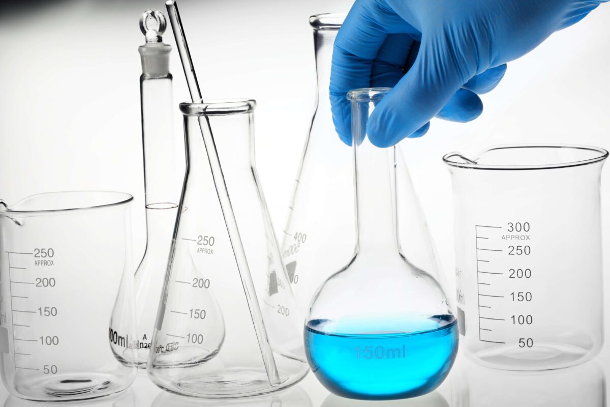 Chemist holds a flask containing a blue chemical